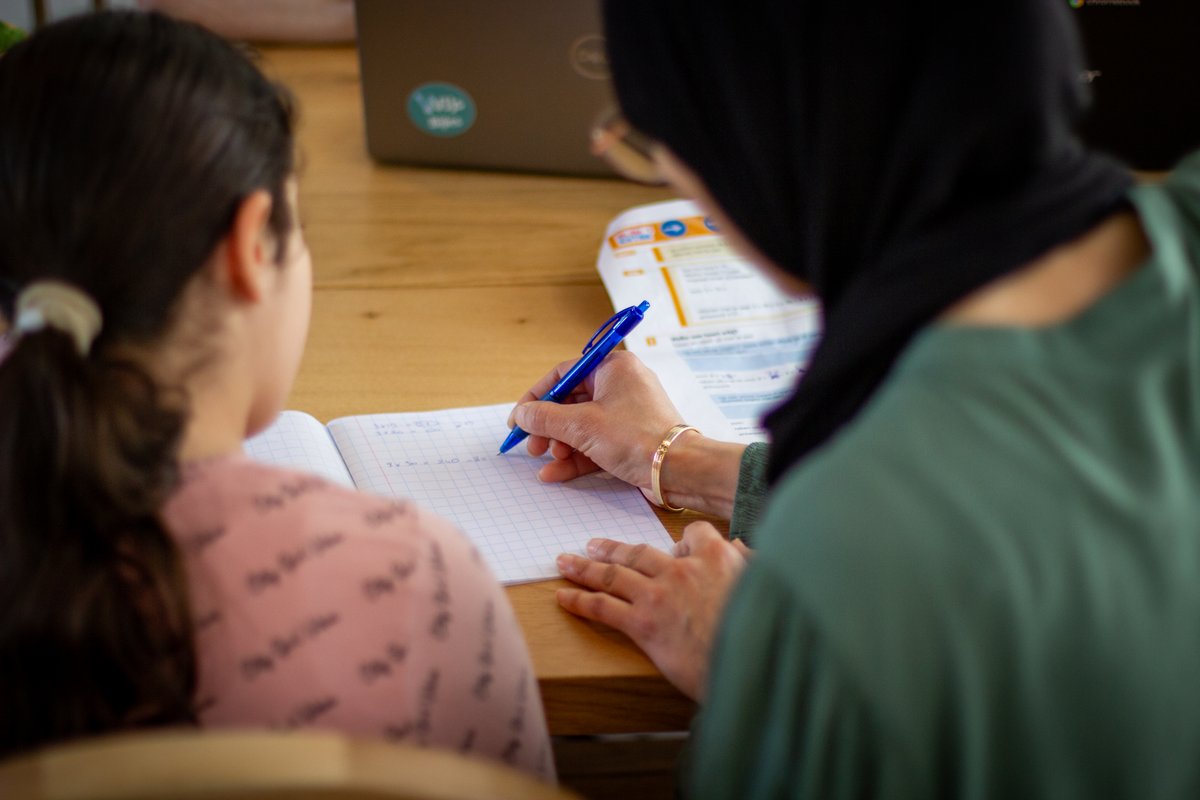 Een bijlesdocent van WIJs helpt een leerling met schrijven